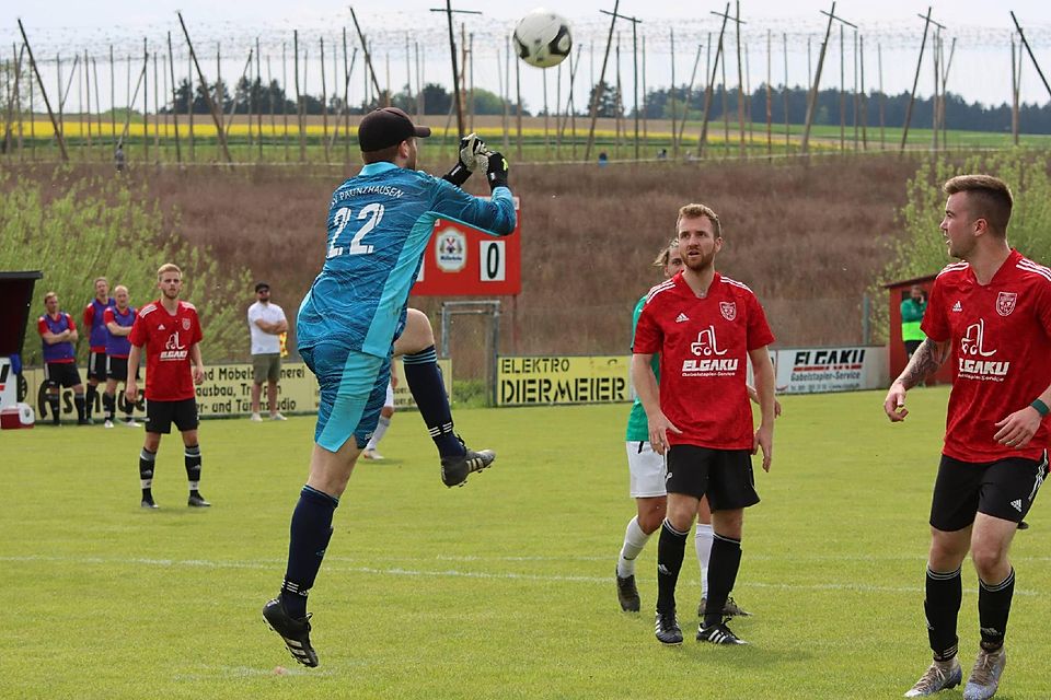Haltungsnote Eins: Paunzhausens Schlussmann Julius Gassner faustet im Spiel gegen die FVgg Gammelsdorf einen hohen Ball gekonnt weg. Seine Mitspieler (rote Trikots) schauen ihm gespannt dabei zu.