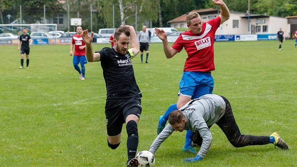 Marcel Vogt von TuS Erbes-Büdesheim angelt verzweifelt nach dem Ball vorm heranstürmenden Weinheimer Marco Storck. Rechts hilft Jermain Walter.	Foto: photoagenten/Carsten Selak