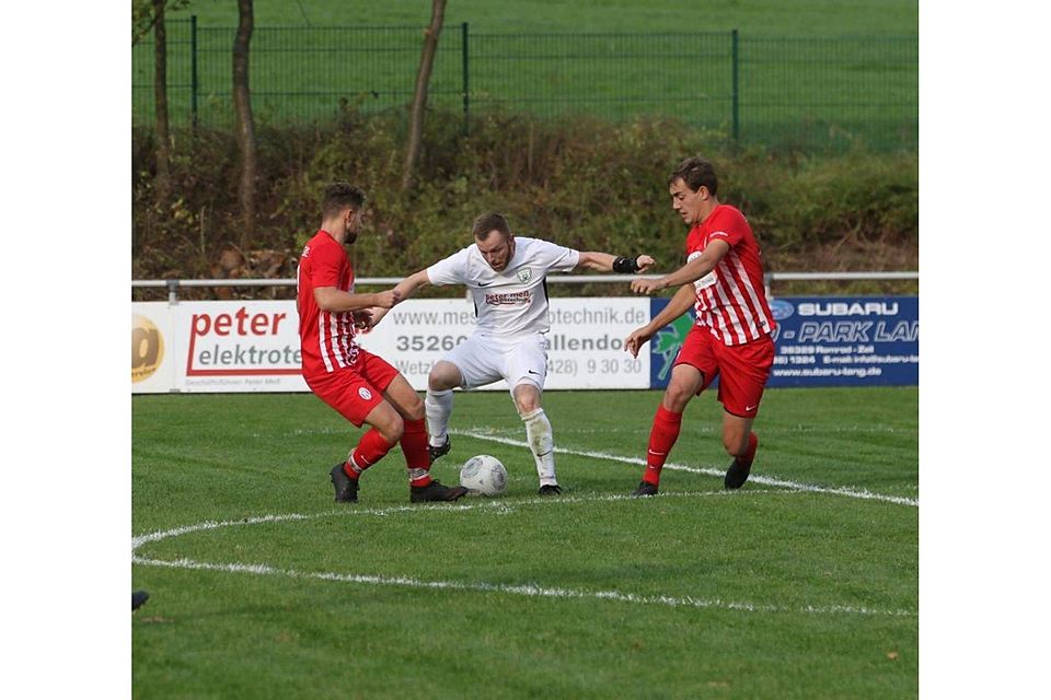 Kirtorfs Spielertrainer Viktor Schulz versucht sich die Mücker Alexander Haak und Mathis Keneder von Leib und Ball zu halten. 	Foto: Luca Raab