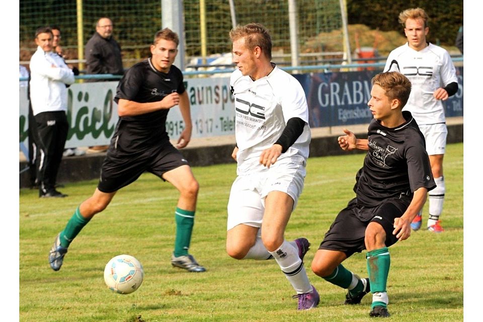 Patrick Schmalzbauer vom FC Hersbruck (Mitte) liefert sich mit einem Mittelfeldspieler des SV Altensittenbach einen Zweikampf auf Höhe der Mittellinie. F: Ruppert