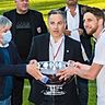 Billy Bernard (r.) und Fola-Präsident Mauro Mariani (M.) bekommen den Meisterpokal vom FLF-Vorsitzenden Paul Philipp überreicht
