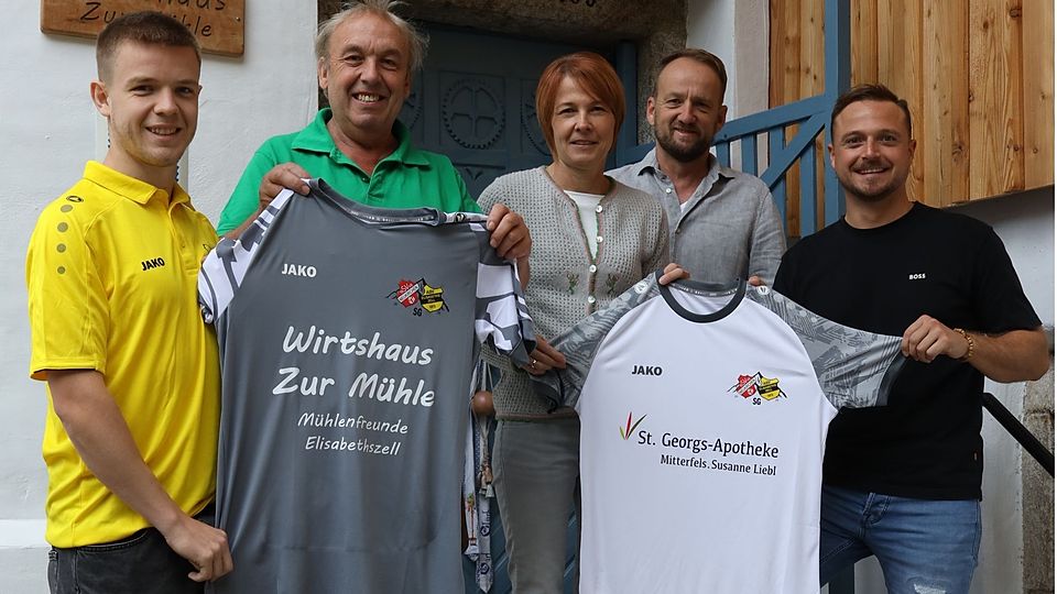 Teammanager Simon Zißler (re.) und die neuen Trikots der SG, die vom Wirtshaus zur Mühle in Elisabethszell und der St. Georgsapotheke in Mitterfels gesponsert wurden.