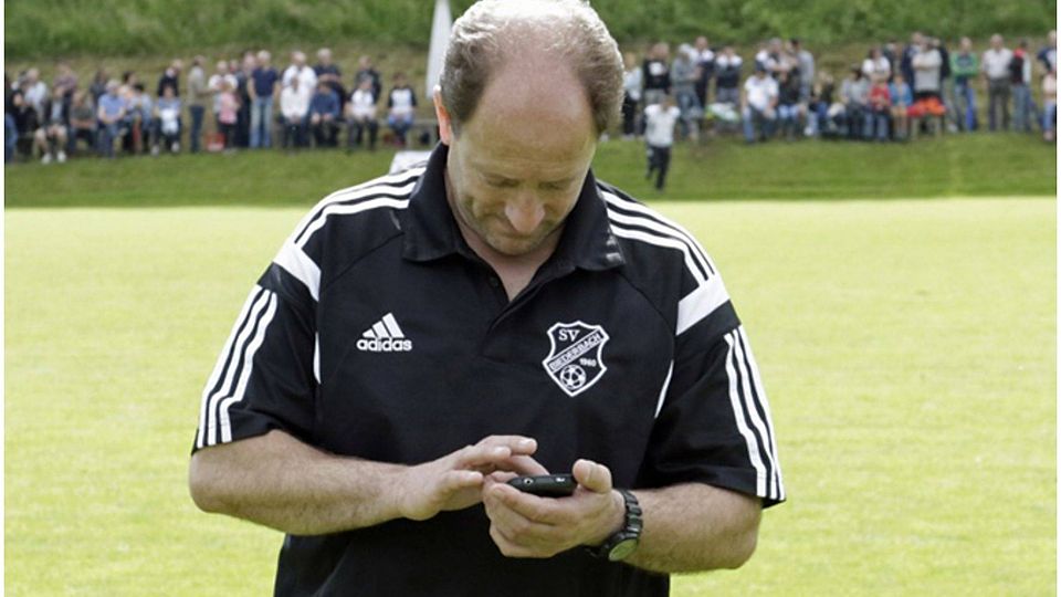 Gebannte Blicke aufs Handy: Biederbachs Trainer Roland Wernet | Foto: Hecht
