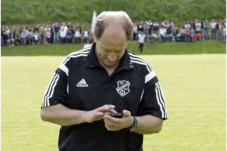 Gebannte Blicke aufs Handy: Biederbachs Trainer Roland Wernet | Foto: Hecht
