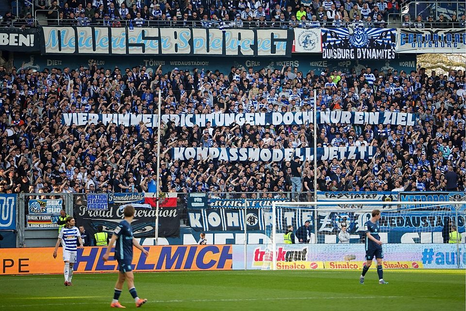 Klare Meinung: Die Fans aus Duisburg geben im Spiel gegen 1860 ihre Meinung zum Besten – „Vier Himmelsrichtungen, doch nur ein Ziel: Kompassmodell jetzt!“