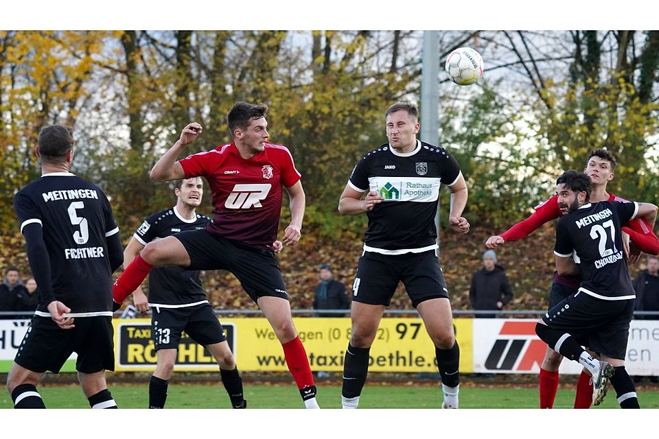 Wertingens Manuel Rueß (links, rotes Trikot) kommt mit dem Kopf vor Raphael Mahler (Mitte rechts, Meitingen) an den Ball.