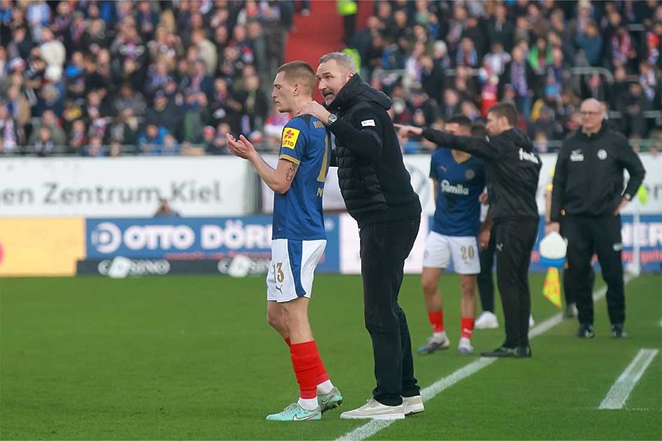 Cheftrainer Tim Walter (Holstein Kiel) bespricht mit Ivan Nekic während des Spiels Details.