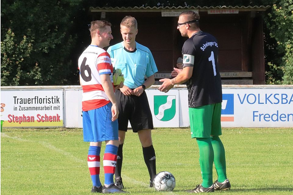 Vor dem Spiel gab es Geschenke: Kevin Hellwege überreichte dem Kapitän Timo Dietrich ein Präsent. In der Mitte Schiedsrichter Yannick-Fynn Blattner.