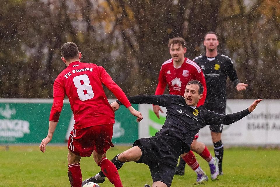 Deftige Duelle im Dauerregen: Moosinnings Benedikt Thumbs grätscht auf dem tiefen Geläuf in den Zweikampf mit Finsings Kilian Schmitt (l.). Am Ende des Landkreis-Derbys steht eine 2:2-Punkteteilung.