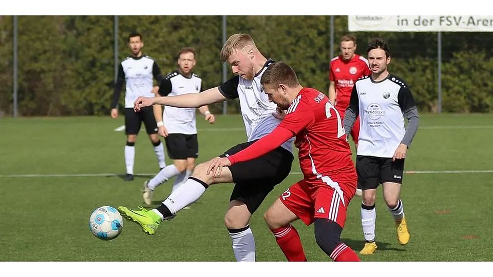 Maurice Braun im weißen Trikot des FSV Manderbach war einer der wesentlichen Torschützen. In dieser Szene ist der Oberschelder Nils Metzler sein Gegenspieler. © Lorenz Pietzsch