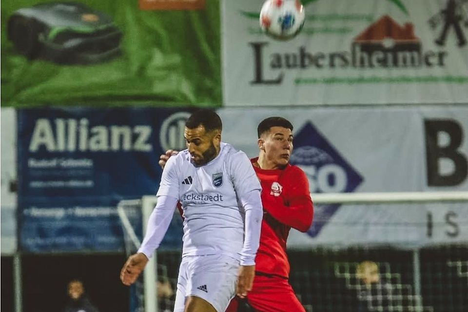 Lieferten sich ein heiß umkämpftes Halbfinale: die Verbandsliga-Kicker der TuS Mechtersheim (in weißen Trikots, hier Andrew Wooten) und die Regionalliga-Fußballer des TSV Schott (in rot Maurizio Robotta). Foto: TSV Schott Mainz/Chiara Puci