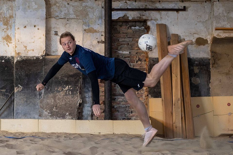 Gar nicht so einfach: Max Backhaus übt im weichen Sand eines Beachvolleyballfeldes den Scorpion-Kick von Gladbach-Stürmer Valentino Lazaro.