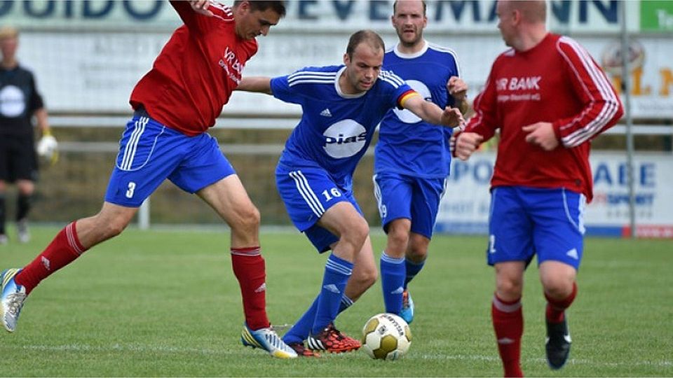 Von seinen Ideen lebt das Neuenkirchener Spiel: TuS-Kapitän Jan-Bernd MIddendorf (in Blau). Dirk Neuendorf beobachtet. Foto: Rolf Kamper