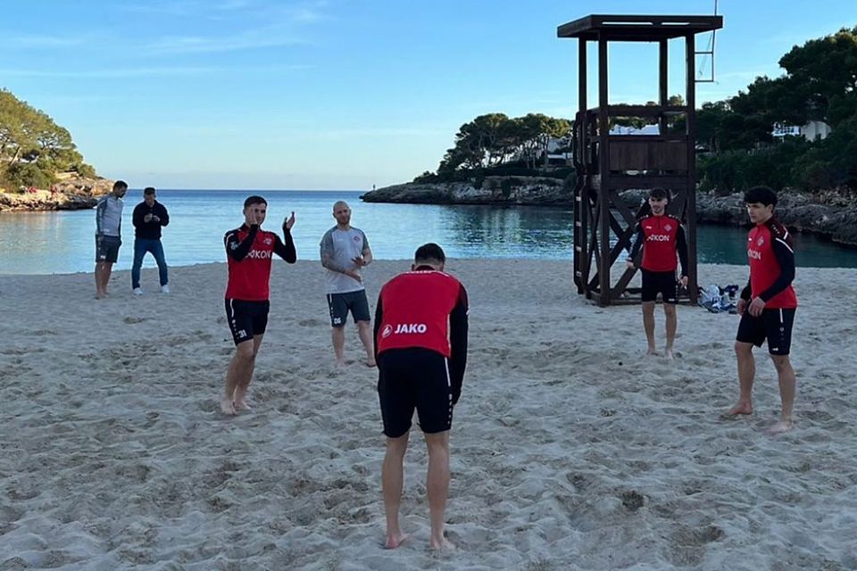 Vor der Kulisse lässt es sich gleich leichter arbeiten: Die Kickers entspannen zwischen zwei Trainingseinheiten an einem mallorquinischen Strand. 