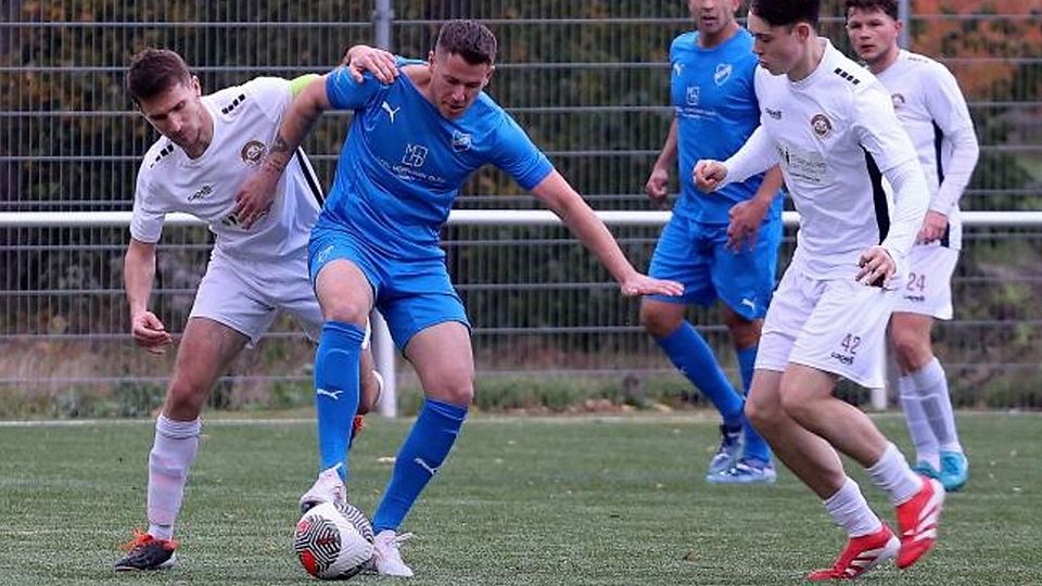 Hackenheims Kapitän Oliver Gäns (weißes Trikot, links) stört den Rieschweilerer Weltmeister Erik Durm.	Foto: Mario Luge