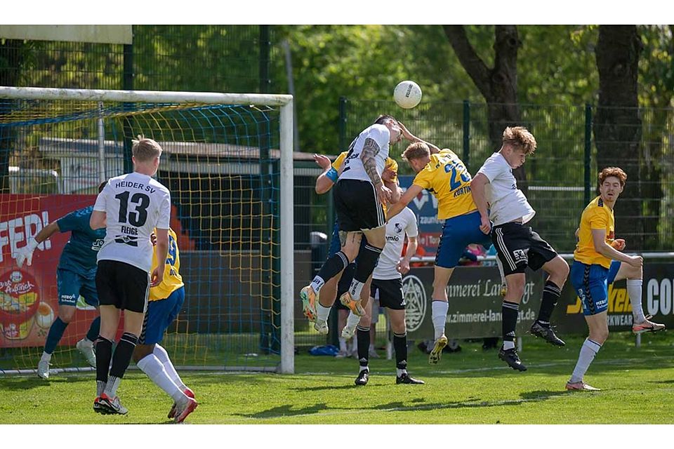 Mika Kieselbach (Heider SV) köpft den Ball vor Tyler Körting (SV Todesfelde) weg.