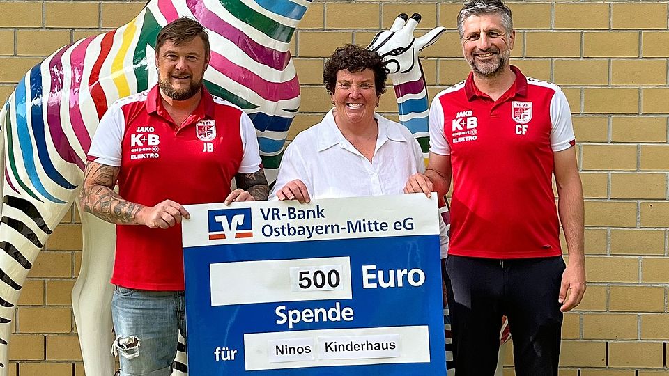 Johannes Bucher (links) und Christian Fleischmann (rechts) von der Fußballabteilung des TB 03 Roding übergeben den symbolischen Spendenscheck an Karin Borchers vom Verein Ninos Freunde e.V.