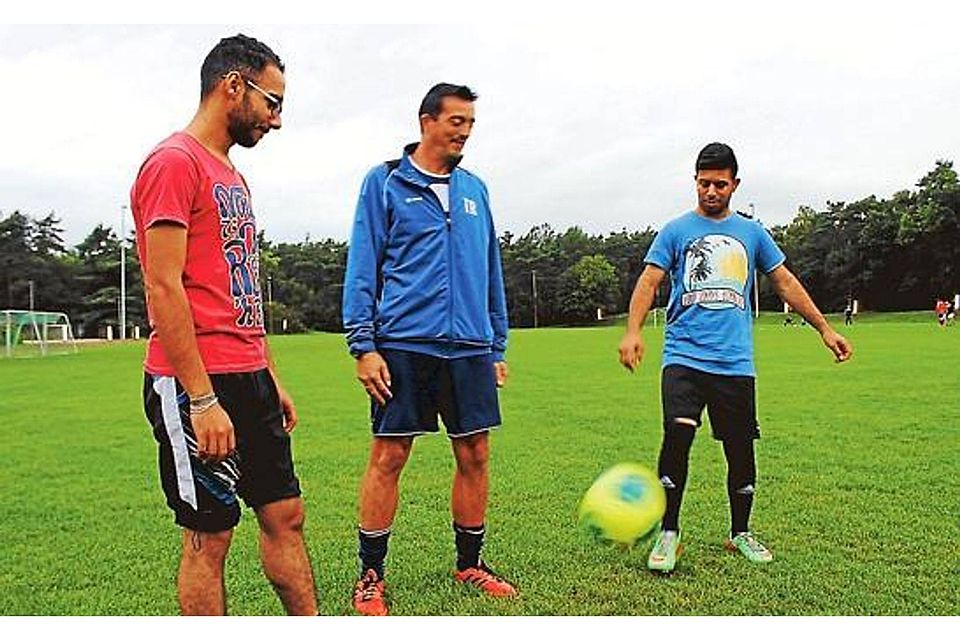 Fußball verbindet: Zaher Haj Khalaf (23), Trainer Piet Seyen und Zozo Lazar (18, von links) auf dem Fußballplatz der TSG Hatten-Sandkrug. Die beiden Syrer Werner Fademrecht