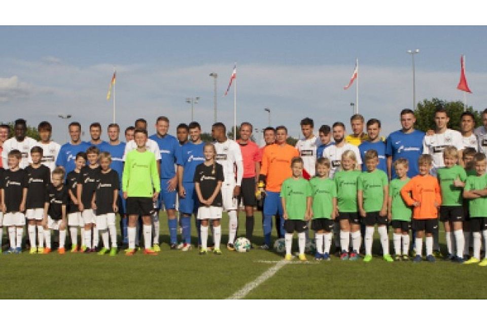 Ein buntgemischtes Gruppenbild: Die Eintracht-Profis in Weiß mit den Spielern der SG Treis/Allendorf und den (grünen) F-Junioren der JSG Lumdatal.	Foto: Hahn