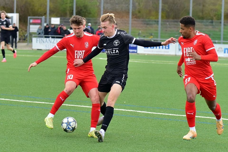 Im Zweikampf auf dem Kunstrasen des Lettenpark behaken sich Jonathan Ehret vom FC Auggen (links) und David Trenkle von den SF Elzach-Yach, rechts läuft Julien Tschira.