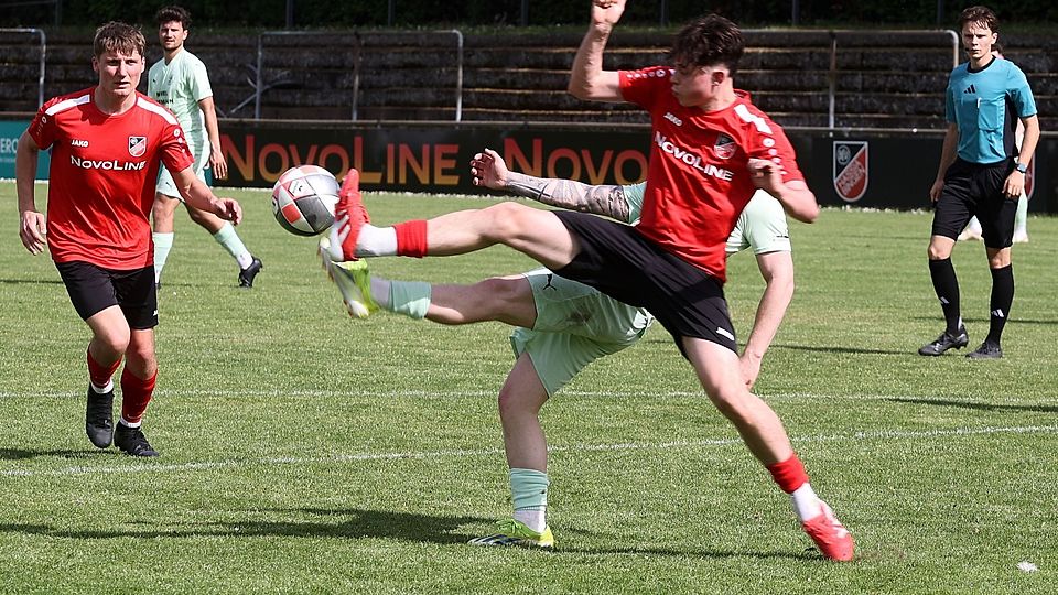 Felix Hadamitzky (rotes Trikot) kommt mit der Fußspitze gegen Grünstadt als Erster an den Ball.