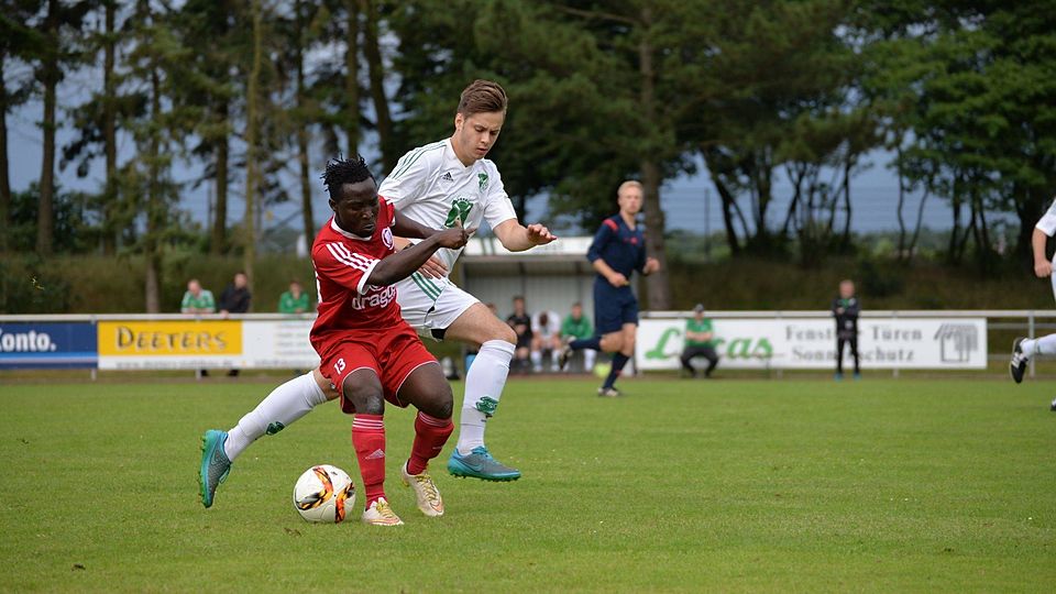 Ismael Konate (rotes Trikot) vom SV Union Lohne im Duell mit dem Baccumer Christian Pertz. Foto: Wilfried Roggendorf