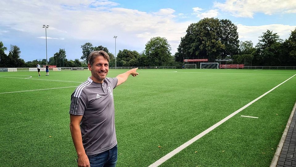 Be­ne­dikt Nie­sen, Vor­sit­zen­der des FC Bü­de­rich, zeigt den Kunst­ra­sen­platz auf dem künf­tig die Top-Ta­len­te trai­nie­ren sol­len.