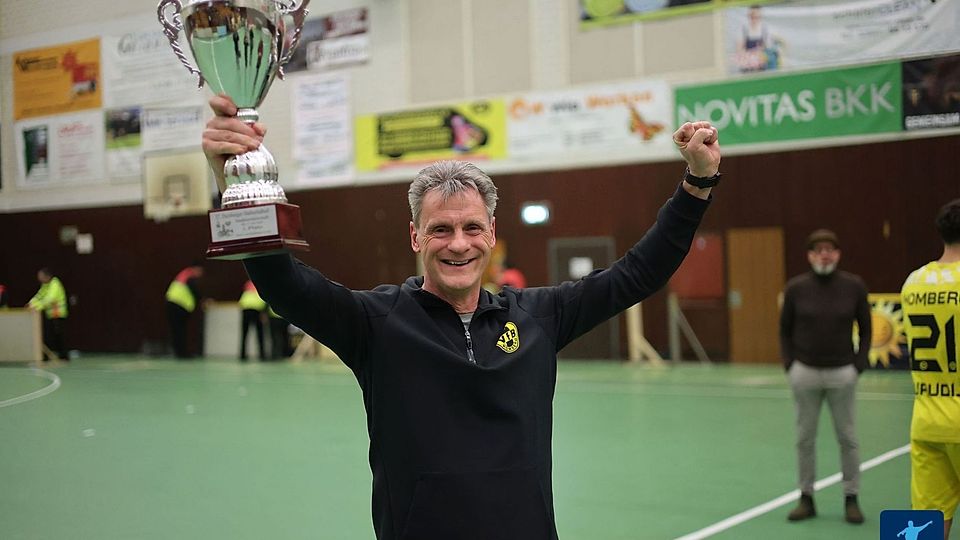 Stefan Janßen reckt den Pokal der HStM Dusiburg in die Höhe.
