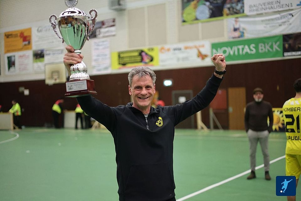 Stefan Janßen reckt den Pokal der HStM Dusiburg in die Höhe.