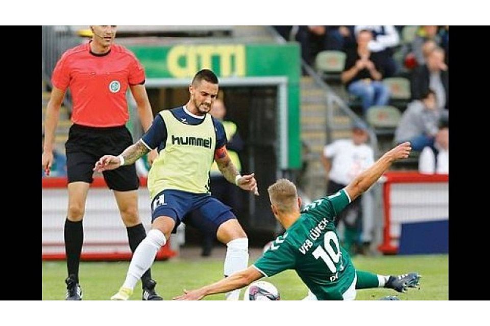 Verbissen: VfB-Kapitän Daniel Franziskus (gelbes Leibchen) kämpft mit Lübecks Yannick Deichmann um den Ball. Schiedsrichter Patrick Schult beobachtet die Szene.