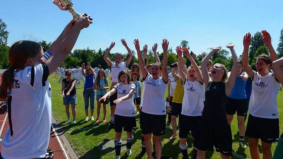 Spielführerin Stefanie Flamm (links) reckt den Bezirkspokal in die Höhe, das ganze Römersteiner Team feiert euphorisch.