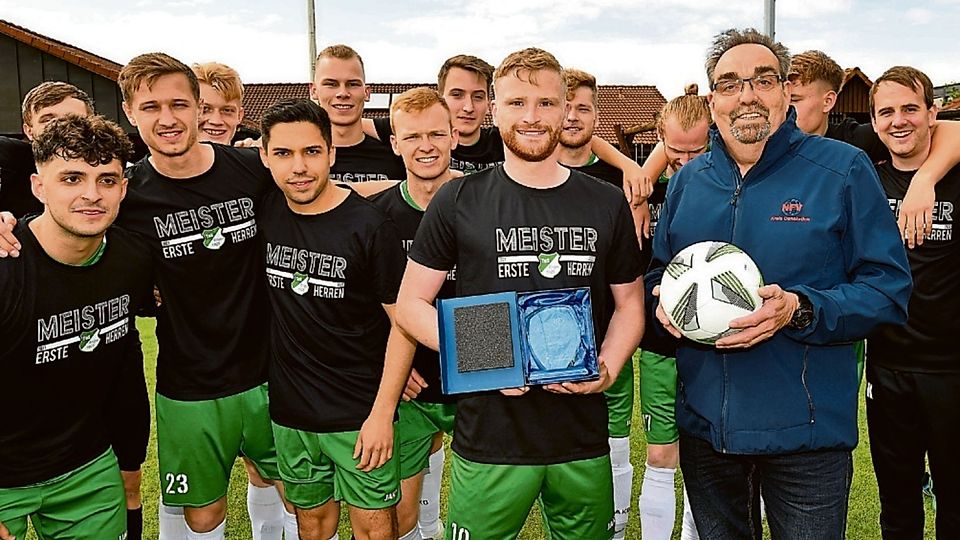 Staffelleiter Ulrich Stenzel (mit Ball) überreichte die Trophäe an TuS-Kapitän Lukas Prätorius.