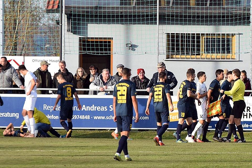 Während die Pipinsrieder auf den Schiedsrichter einstürmen, kümmert sich Schwabmünchens Mannschaftsarzt Florian Döbereiner um den verletzten Amar Cekic. Später bekam er noch Unterstützung von TSV-Betreuerin Magdalene Burghold.