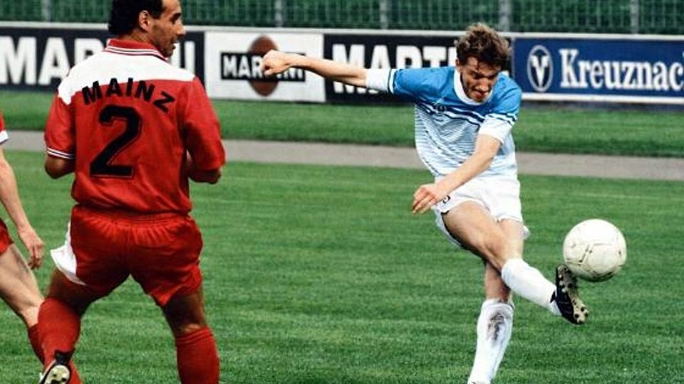 Mario Spreitzer im Jahre 1988 und im weiß-blauen Trikot von Eintracht Kreuznach beim Oberliga-Spiel gegen den 1. FSV Mainz 05 um Verteidiger Michael Schmitt (links), das die Nullfünfer mit 3:1 gewannen. 	Foto: AZ-Archiv (nachcoloriert)