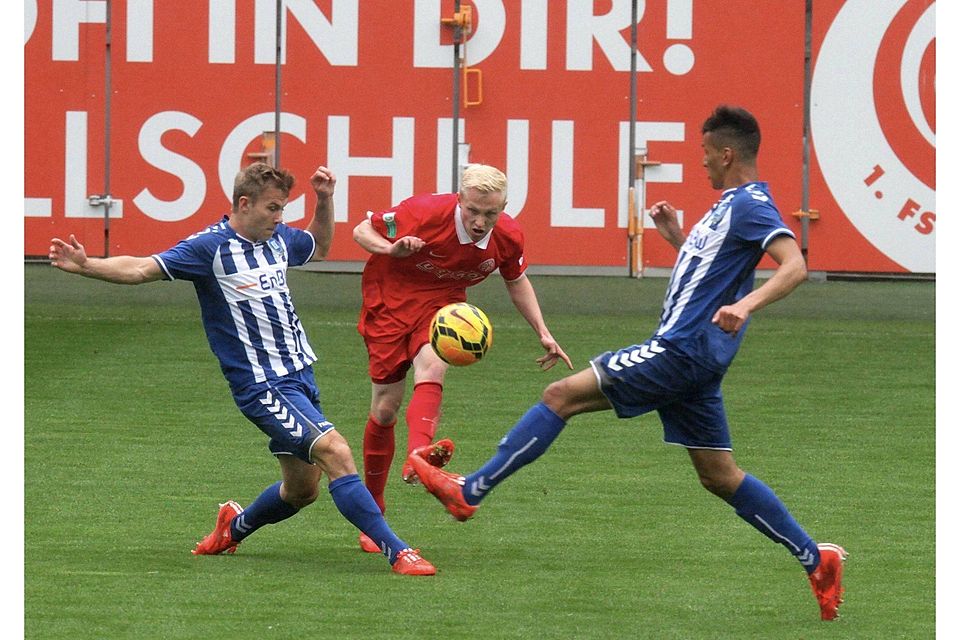 Ab durch die Mitte: Der Mainzer Patrick Pflücke (Mitte) spielt den Ball zwischen den Karlsruhern Pierre Fassnacht (links) und Demarveay Sheron hindurch.	Foto: hbz/Jörg Henkel