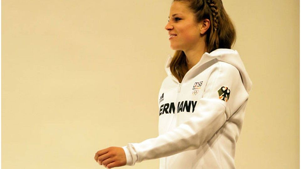 Auf dem Fußballplatz eben Meister geworden, präsentiert Melanie Leupolz hier die Kleidung für die Olympischen Spiele. 	F.: nordphoto