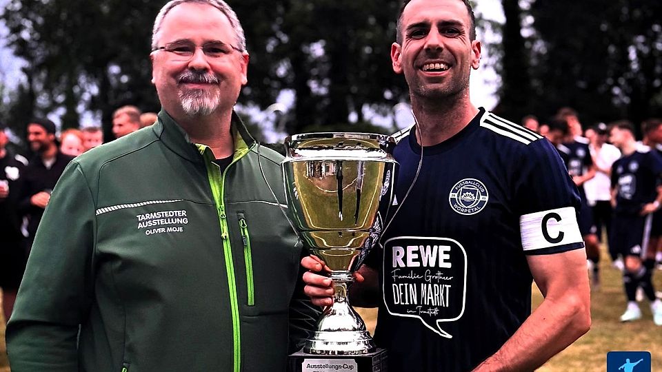 Nach dem Abpfiff des Endspiels überreichte Oliver Moje, Geschäftsführer der Ausstellungs-GmbH Tarmstedt und Samtgemeindebürgermeister den Siegerpokal an FC-Kapitän Kevin Murley.