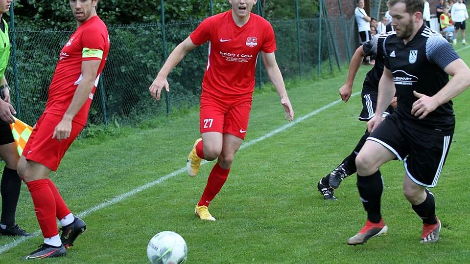 Hüffelsheims Tom Baier schaut dem Ball hinterher, Kapitän Johannes Balzer macht den Weg frei.