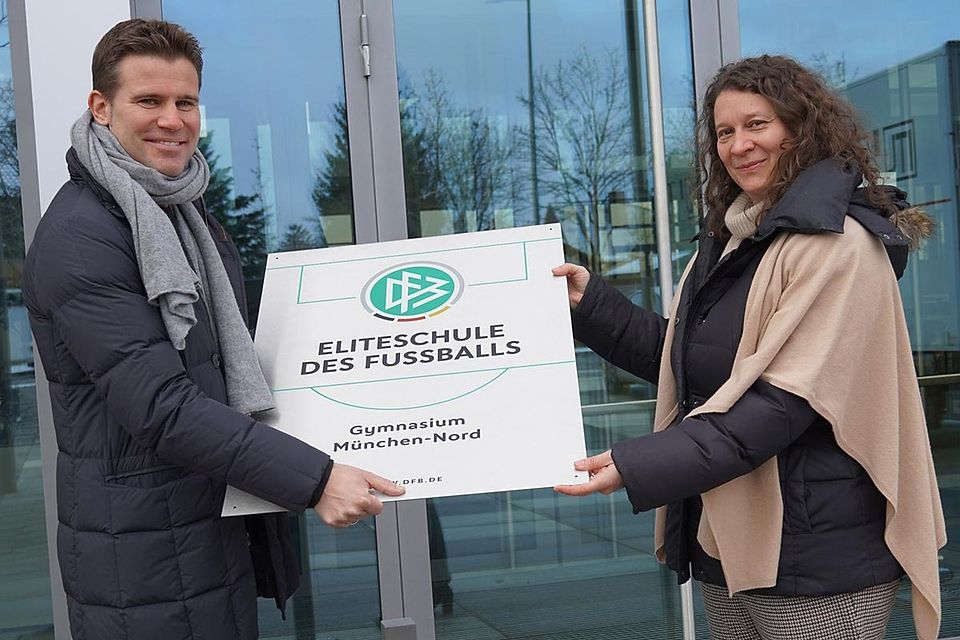 Felix Brych übergibt Schulleiterin Dr. Petra Reinold feierlich die Plakette: Das Gymnasium München-Nord darf sich „Eliteschule des Fußballs“ nennen.