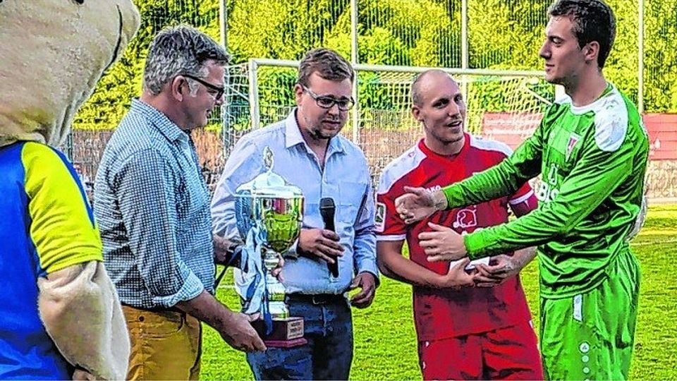 Von links: Jakob Braun von der Sparkasse Düren und Mario Lenzen überreichen Maurice Passage und FC-Torwart Stefan Nöhles „Cup“ und Prämie.