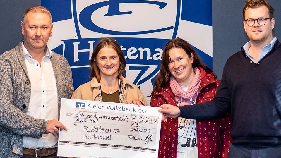    Tobias Kasimir (FC Holtenau 07, li.) und Heiko Petersen (Holstein Kiel, re.) übergaben den Spendencheck an die Leiterinnen der Gemeinschaftsunterkunft Schusterkrug Nicole Zander (M. li.) und Sirli Hinz (M. re.).  