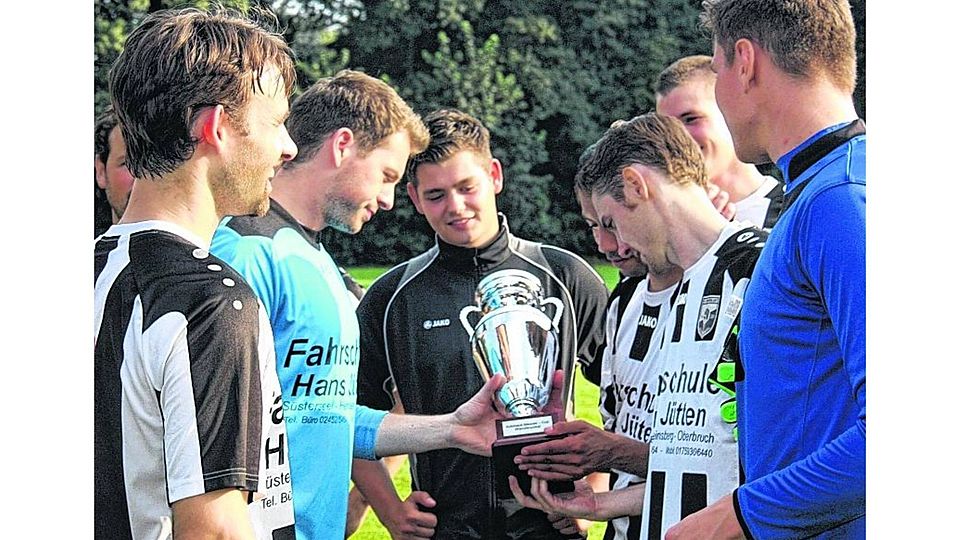 Stolze Sieger: Die Spieler des FC Wanderlust Süsterseel begutachten den Cup. Foto: agsb