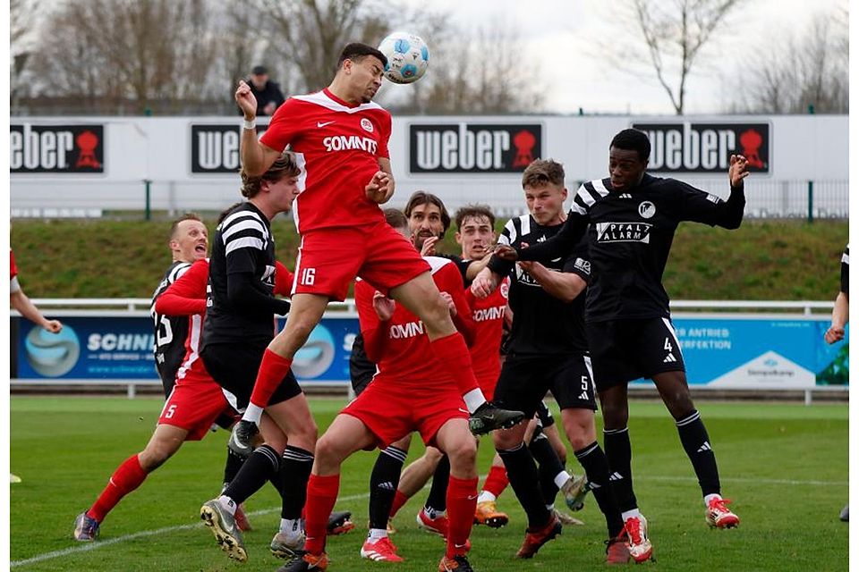 Hüffelsheims Malik Yerima (rotes Trikot) setzt sich im Kopfballduell durch. 	Foto: Edgar Daudistel