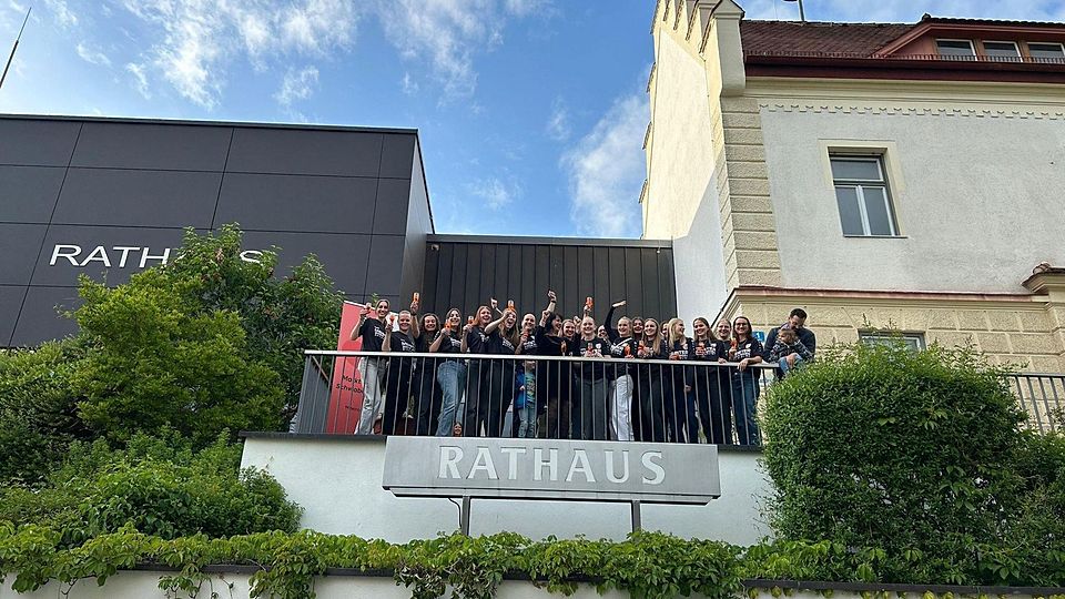 Die Meisterinnen des FC Markt Schwaben grüßen vom Rathaus-Balkon (v.l.): Ida Schulmeyer, Laura Schreil, Nadja Rimschneider, Bettina Gruber, Anna Liebelt, Elisabeth Weber, Lea Schmitt mit Luis Reiter, Bürgermeisterin Walentina Dahms, Rebecca Eberherr, Eva Schmitt, Spielertrainerin Laura Staudigl, Hannah Bauer, Vroni Meier, Leonie Meier, Emma Iben, Luisa Bauer, Kristin Desiderato, Eva Zollner, Johanna Gaubatz und Coach Matthias Reiter mit Hannah Reiter.