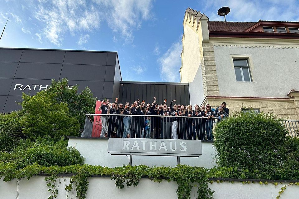 Die Meisterinnen des FC Markt Schwaben grüßen vom Rathaus-Balkon (v.l.): Ida Schulmeyer, Laura Schreil, Nadja Rimschneider, Bettina Gruber, Anna Liebelt, Elisabeth Weber, Lea Schmitt mit Luis Reiter, Bürgermeisterin Walentina Dahms, Rebecca Eberherr, Eva Schmitt, Spielertrainerin Laura Staudigl, Hannah Bauer, Vroni Meier, Leonie Meier, Emma Iben, Luisa Bauer, Kristin Desiderato, Eva Zollner, Johanna Gaubatz und Coach Matthias Reiter mit Hannah Reiter.
