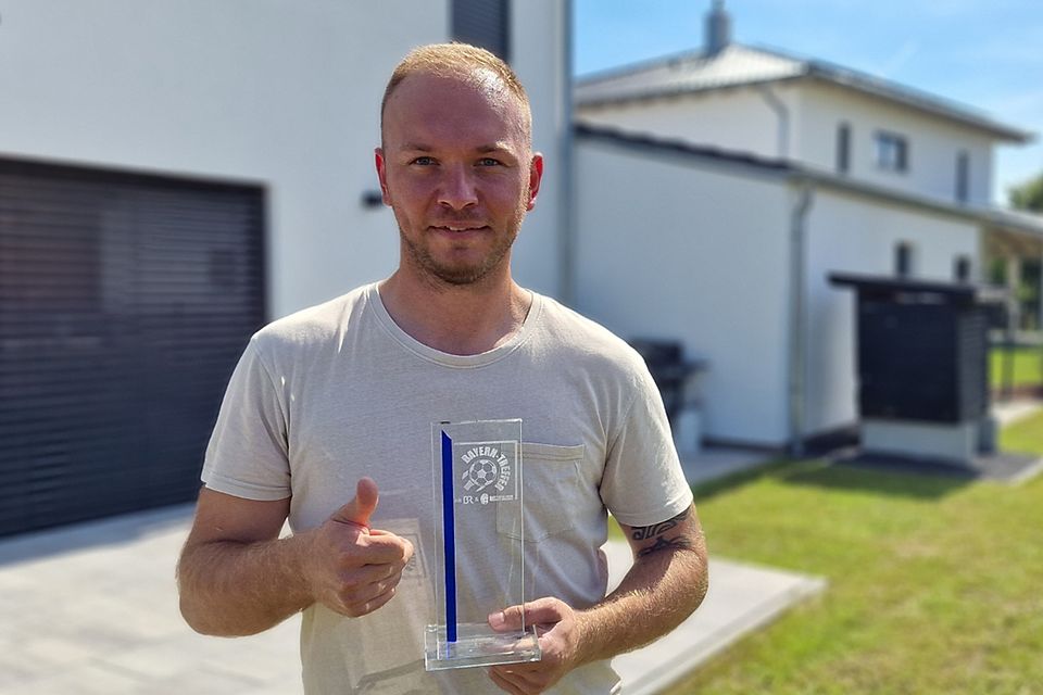 Vilzings Regionalliga-Torhüter Max Putz nimmt die Auszeichnung des Fußball-Verbandes bei sich zuhause entgegen.