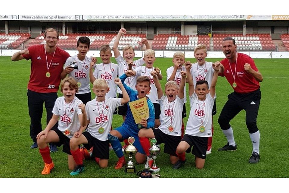 Da haben sie allen Grund zum Jubeln: Die E-Junioren des 1. FC Frankfurt mit ihren Trainern Dominik Rauch (links) und Sascha Geister (rechts) gewannen den Lauzi-Cup, benannt nach dem Maskottchen von Energie Cottbus.  ©Verein