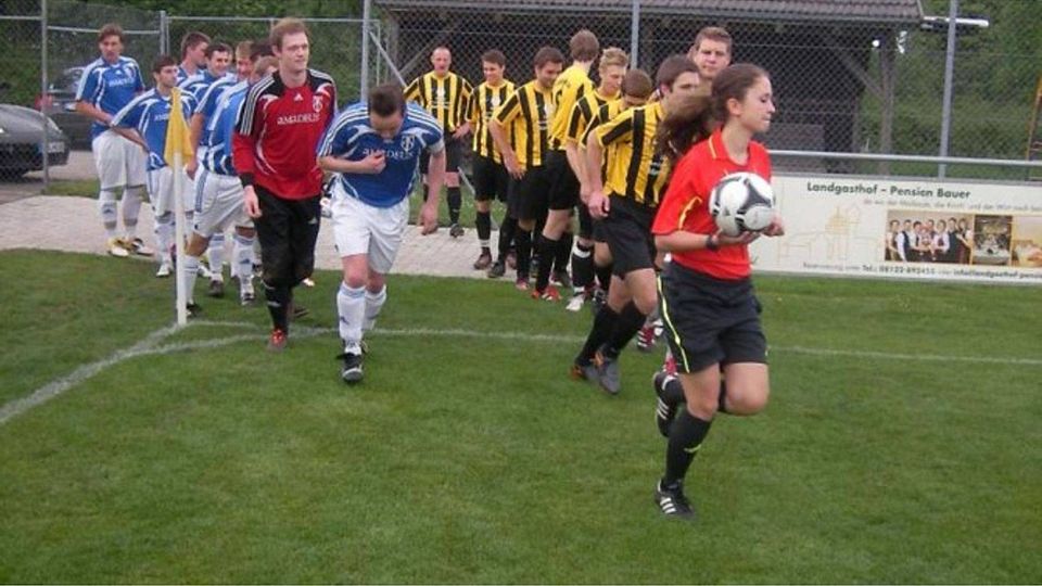 Annemarie Eschbaumer vom FC Fraunberg führt beide Mannschaften im Laufschritt aufs Spielfeld