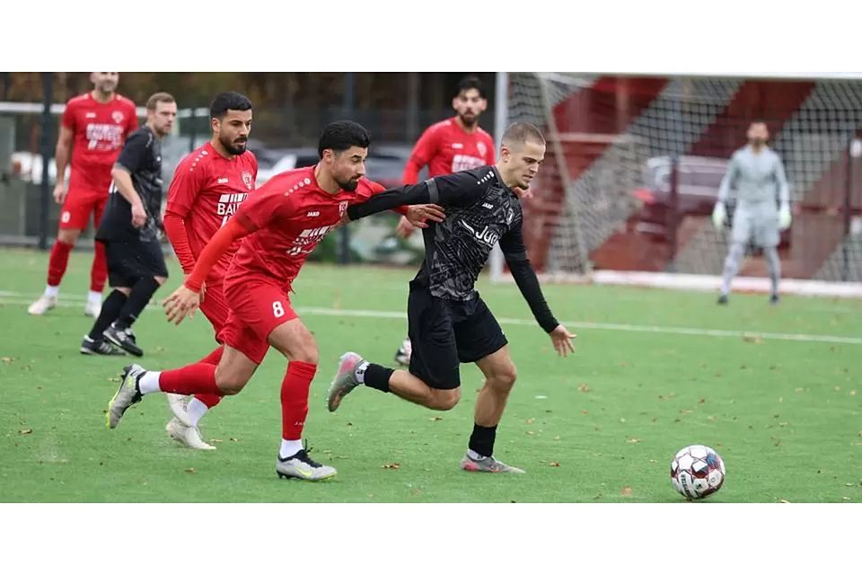 Adil Ibrovic, der hier von Burak Yilmaz nicht zu halten ist, bringt den VfL Weidenhausen auf dem Kunstrasen am Breidenbacher Hausberg mit seinem 13. Saisontreffer in Führung, doch Türk Gücü wendet das Blatt nach der Pause. © Jens Schmidt