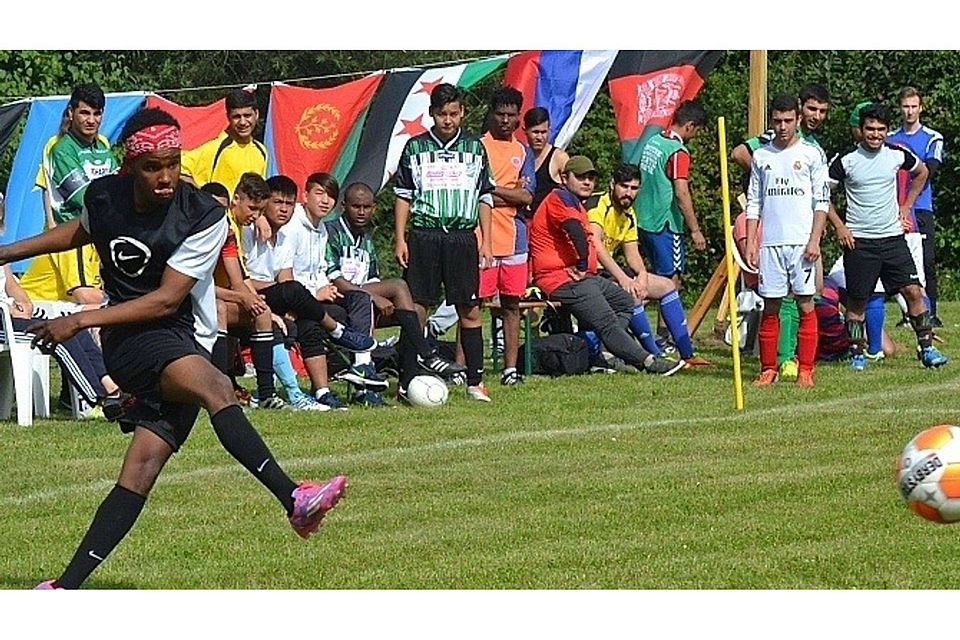 Bunt ging es am Wochenende auf dem kleinen Fußballplatz in Zarnekau zu, wie an den Flaggen zu sehen ist, die für die Herkunftsländer der Teilnehmer stehen. Hier ist Tsgab  aus Eritrea am Ball. Klipp (5)